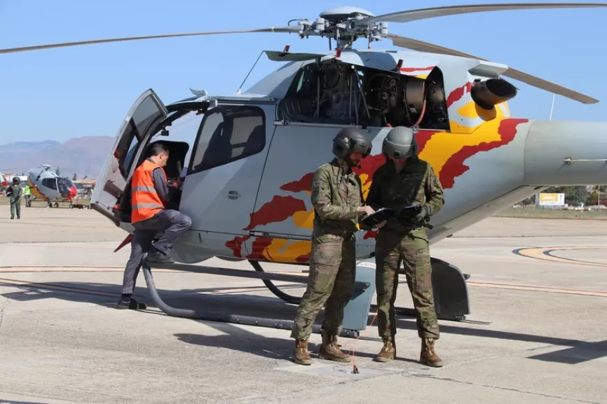Profesor y alumno, en ambos casos de la Aviación del Ejército de Tierra, ante uno de los H120B. Foto: Julio Maíz