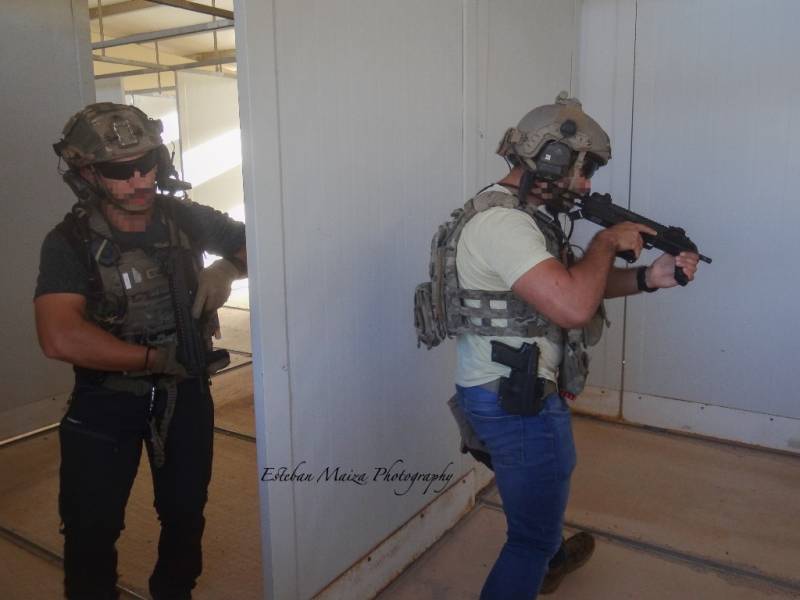 Dos operadores de un equipo especializado en operar en zona gris con vestimenta de civil limpiando una habitacin.