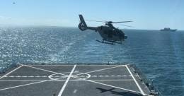 Uno de los nuevos H135 evoluciona sobre la cubierta del Galicia, al fondo se ve el Juan Carlos I. (foto Armada)