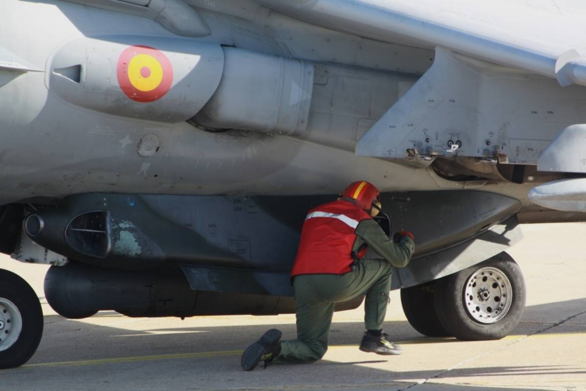 Un armero, como demuestra su chaleco rojo, comprueba el can GAU12 de 25 mm, instalado en la parte inferior del fuselaje del Harrier II.