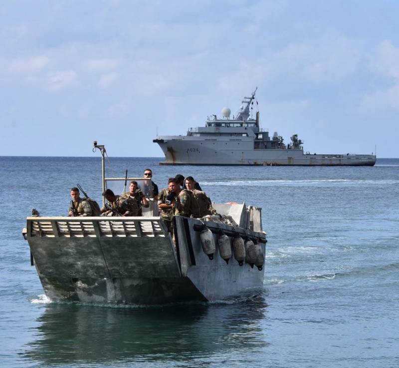 Una barcazas de desembarco lleva a tierra a infantes de marina del 33 RIMa, en el fondo el Dumont d