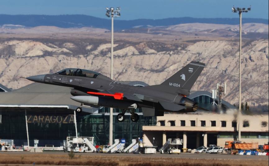 El F-16B (matrícula 1004) de la FAA aterriza en Zaragoza, como muestra el cartel de la terminal del aeropuerto. (defensa.com)